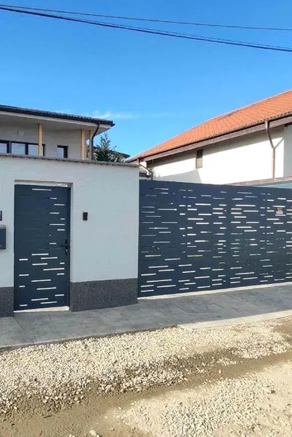 Crna aluminijumska kapija sa pratećom ogradom ispred porodične kuće