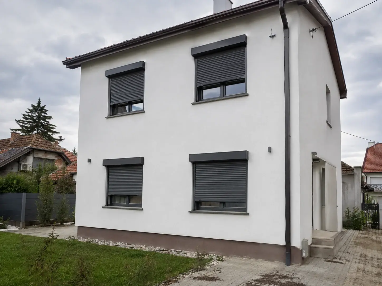 Antracit aluminijumske nadgradne roletne poluspuštene na prozorima porodične kuće