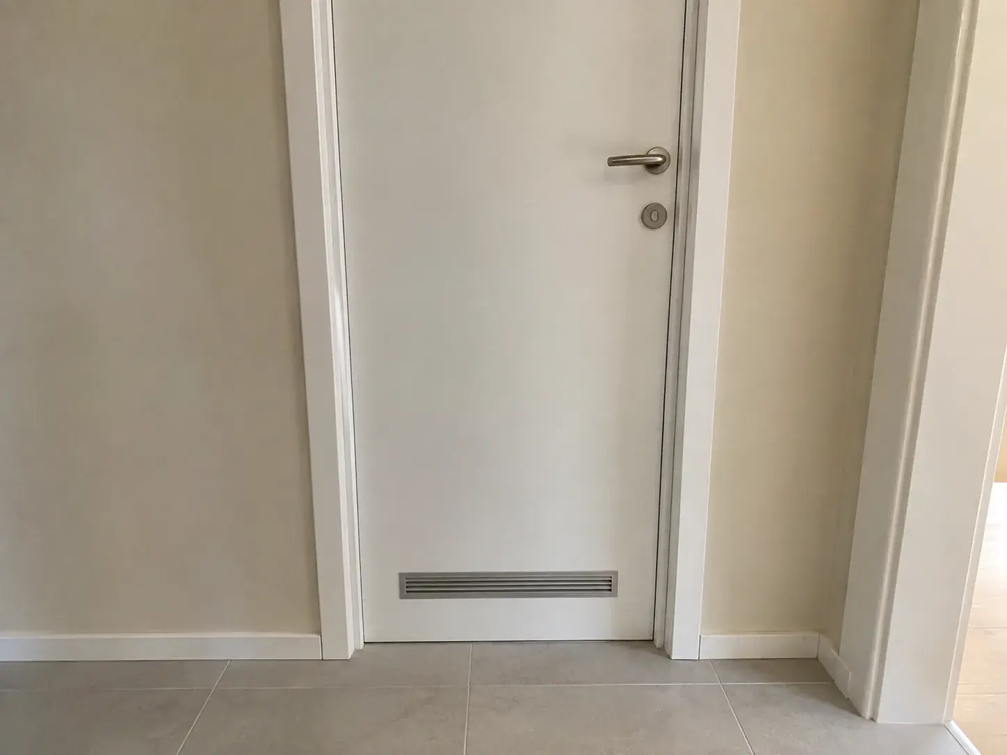 Bela kupatilska vrata sa ventilacionom rešetkom pri dnu krila
