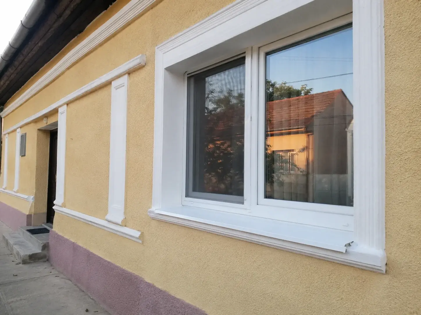 Bačka fasada sa novim PVC prozorom u Sirigu
