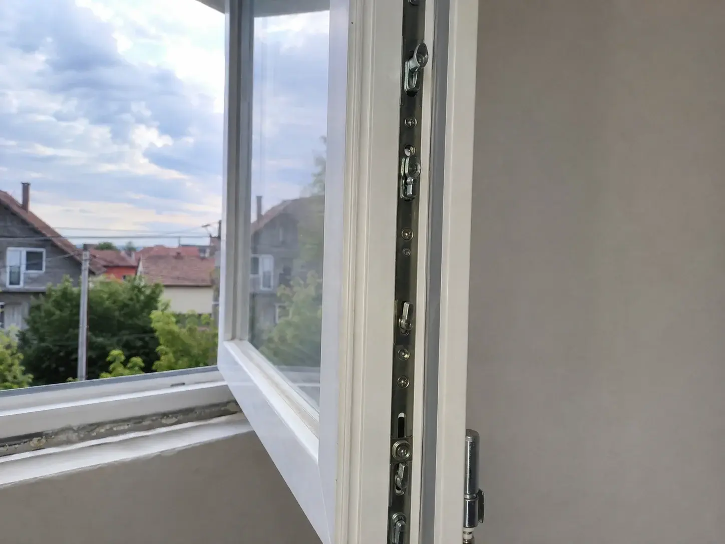 Otvoreno krilo PVC prozora sa vidljivim okovom i tačkama zaključavanja po obodu